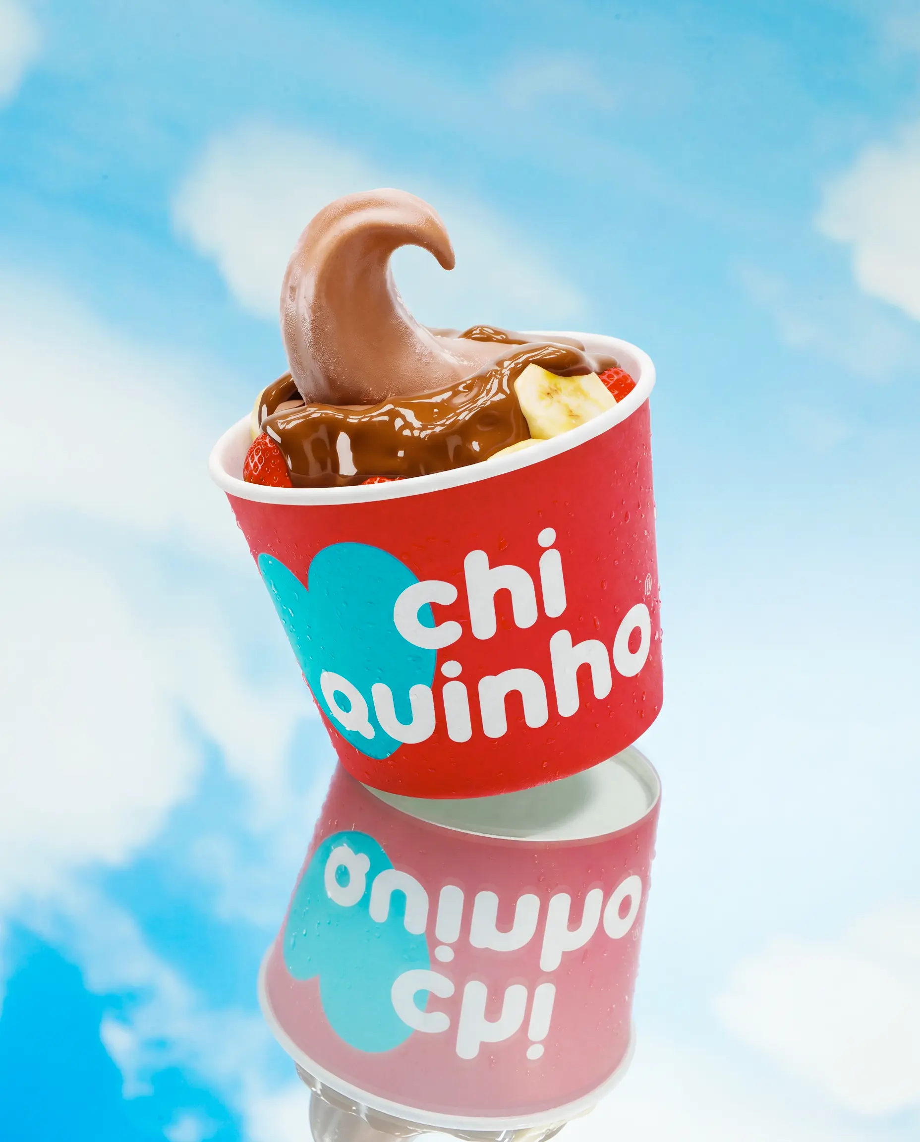 Copo Chiquinho com sorvete de chocolate refletido sobre céu azul