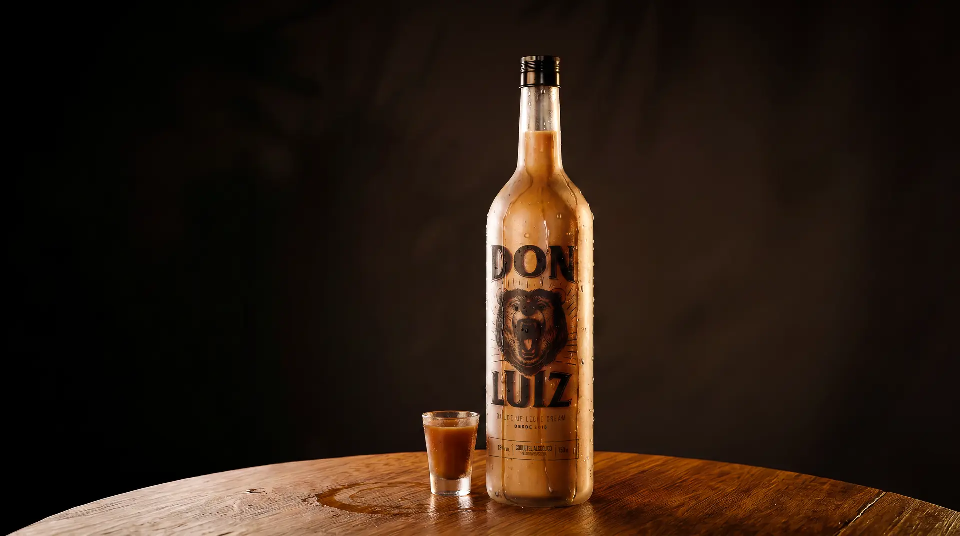 Garrafa e dose de Don Luiz em mesa escura